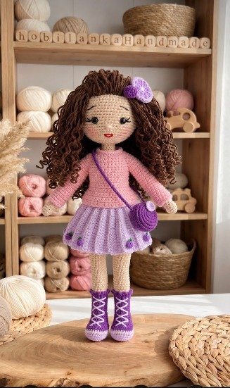 El Örgüsü Amigurumi Kıvırcık Saçlı Kız Bebek – Mor Elbiseli Çantalı Organik Pamuk Oyuncak